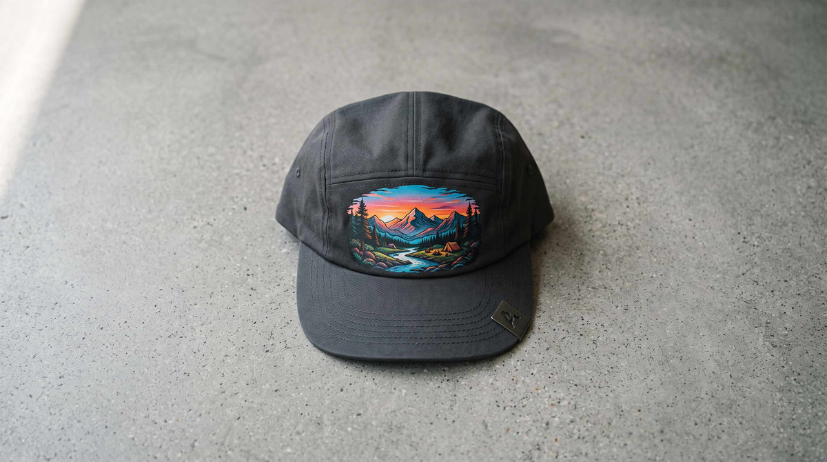Charcoal 5-panel cap with a full-color mountain sunset scene printed on the smooth front panel