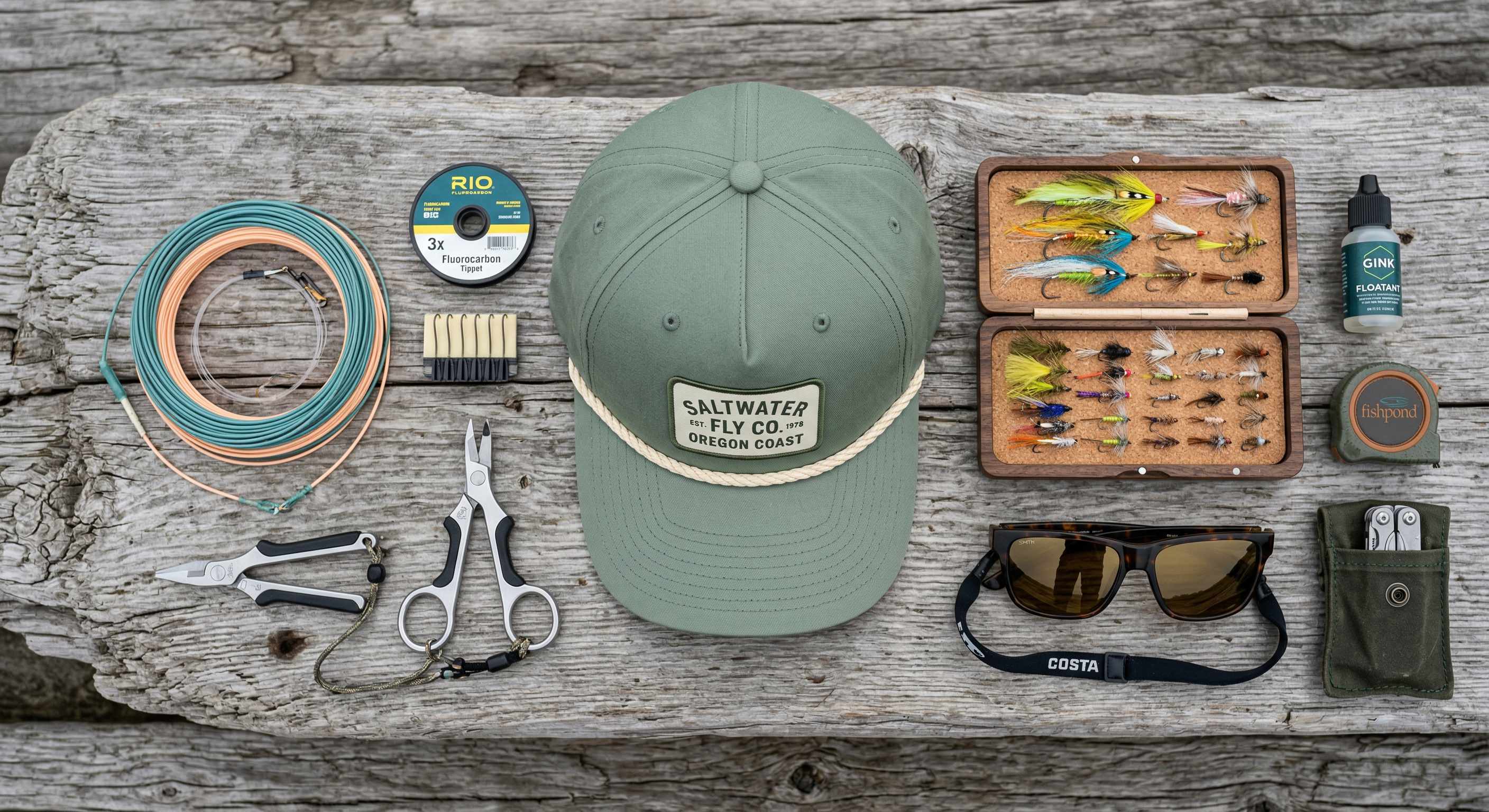 Top-down flat lay of a Sage Green fishing rope hat with fly fishing gear.